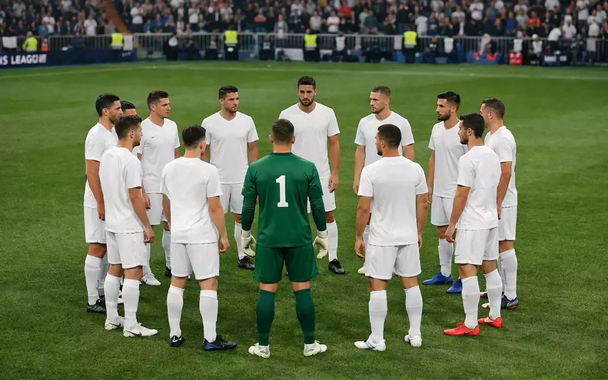 Fußballmannschaft steht im Kreis auf dem Spielfeld vor einem wichtigen Spiel